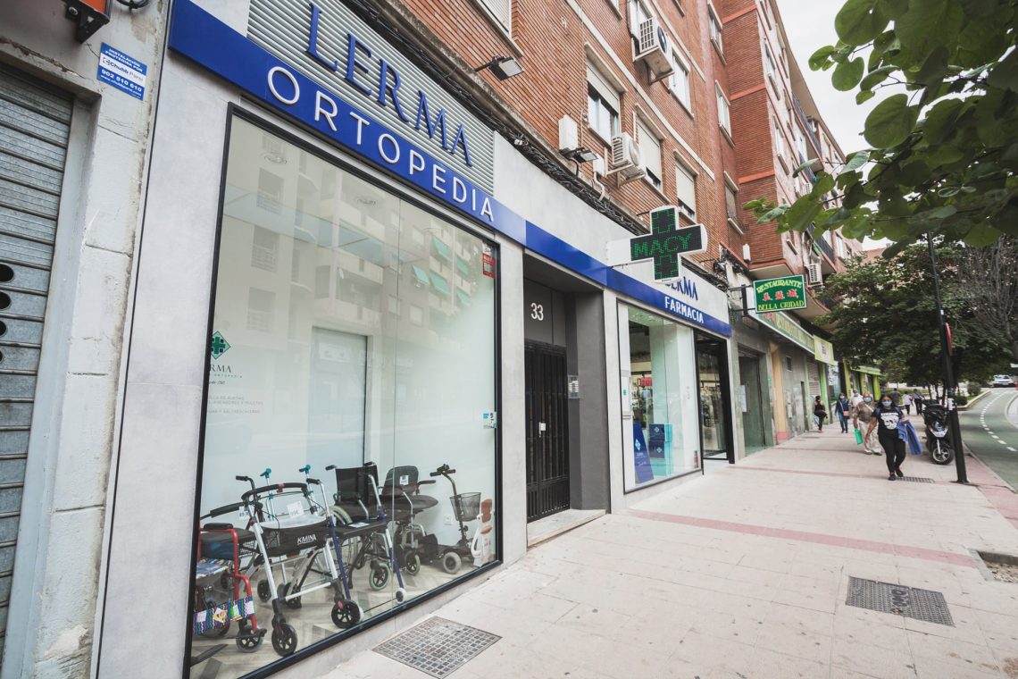 Fachada de Farmacia Lerma Ortopedia en la calle de Zaragoza la Vieja, con productos de movilidad en el escaparate